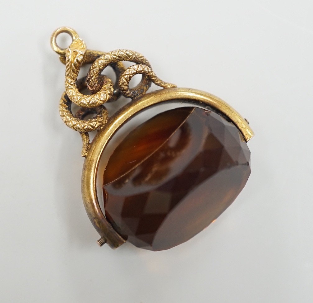 A late Victorian 15ct mounted citrine spinning fob seal, with serpent entwined bale, 34mm, gross weight 11.1 grams.